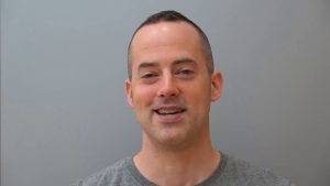 Drew Badger مدرس قناة EnglishAnyone يشرح درس اللغة الإنجليزية على السبورة البيضاء